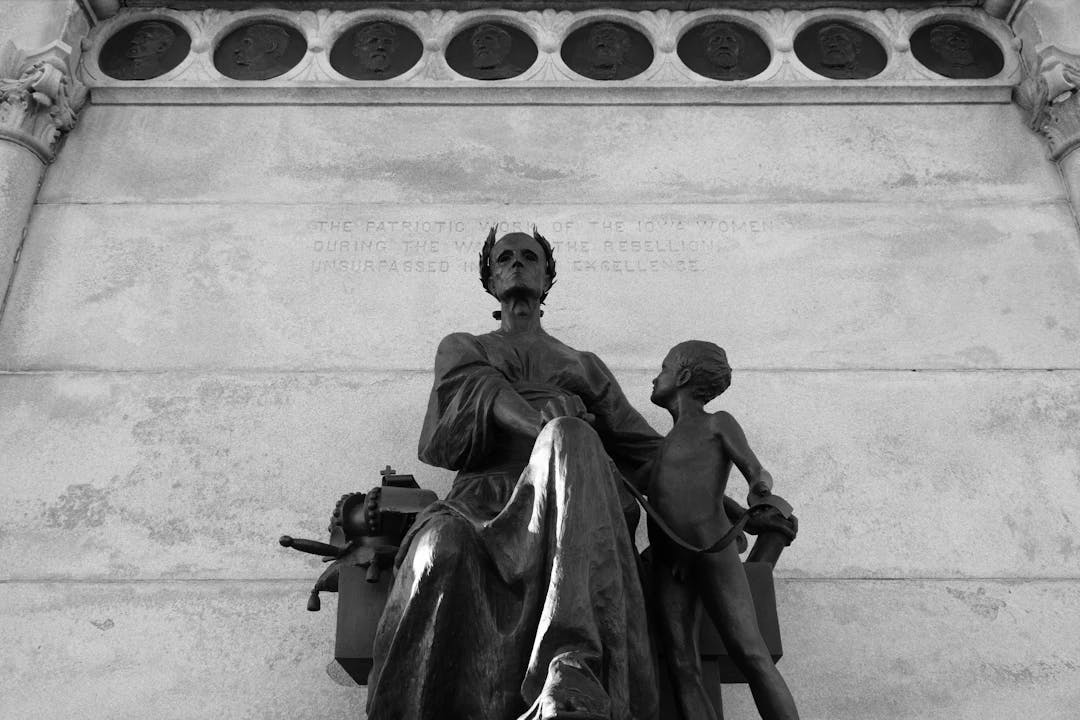 a black and white photo of a statue of a mother and child