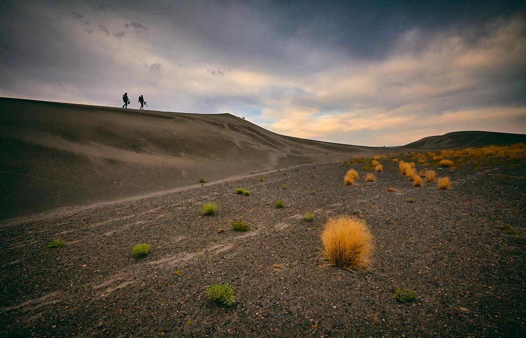 two people walking on desert