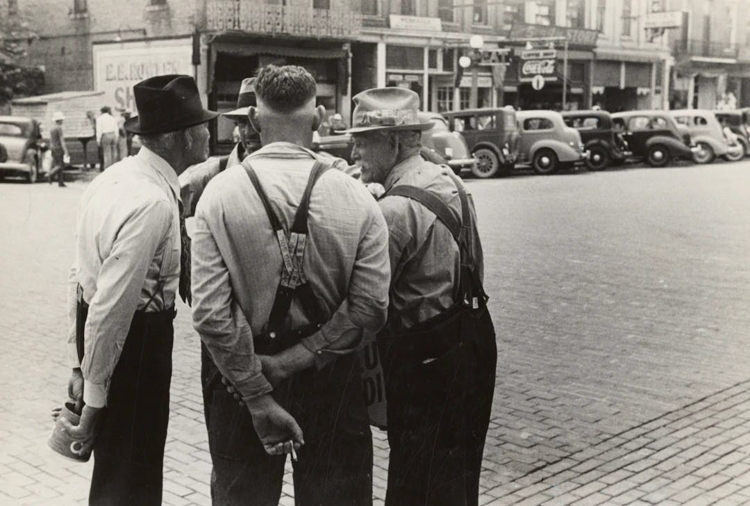 a group of men standing next to each other on a street