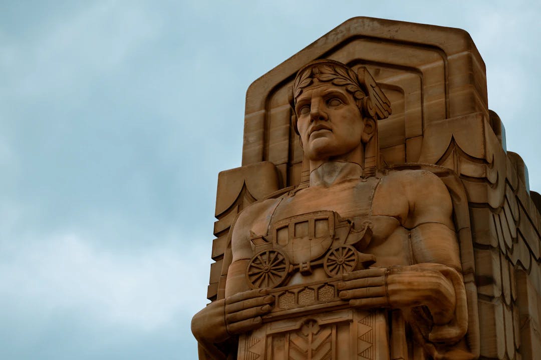 a statue of a man holding a shield on top of a building