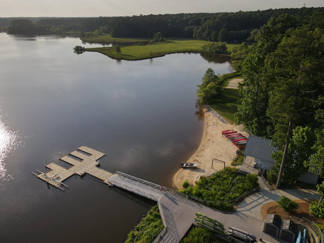 an aerial view of a lake with a dock