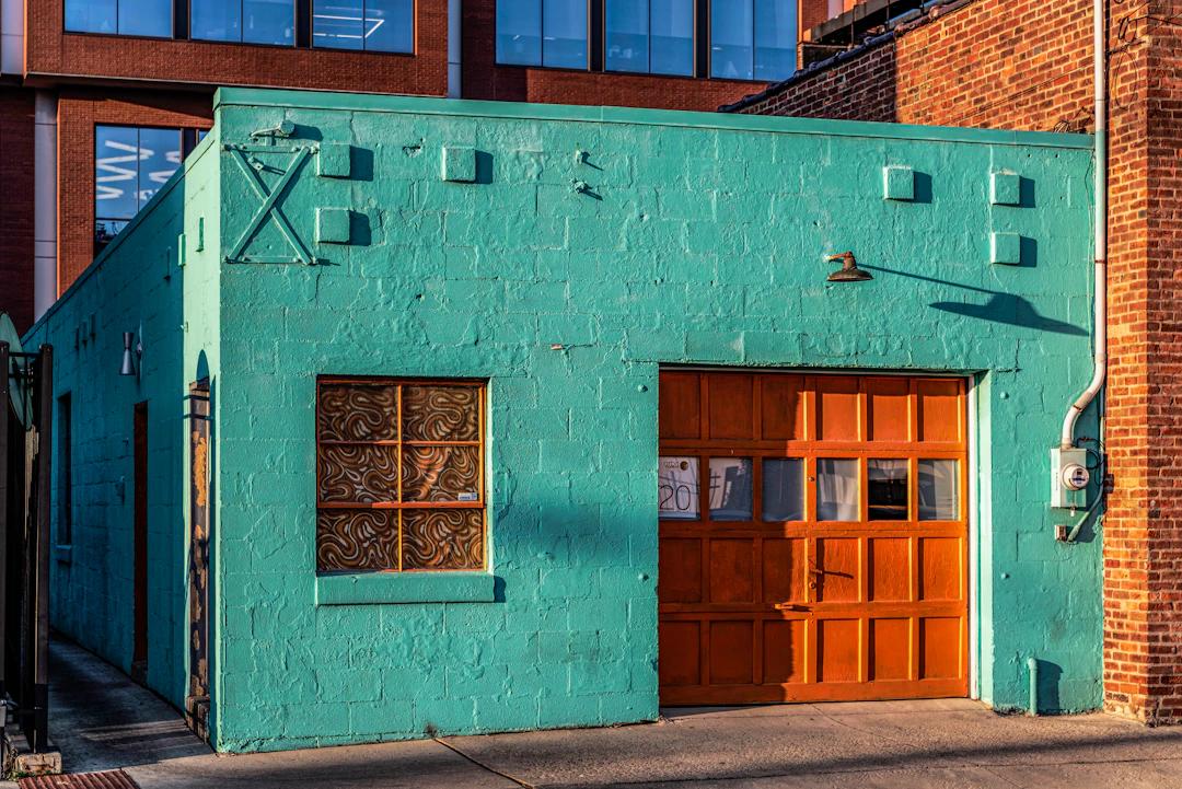 a blue building with a wooden door and windows