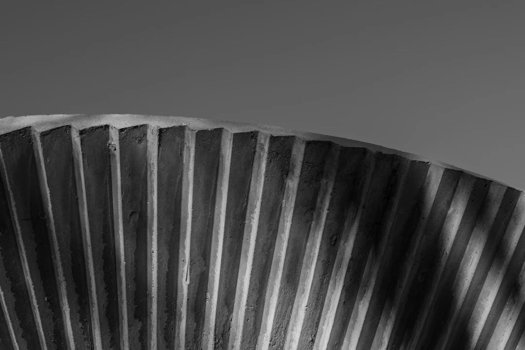 a black and white photo of a curved metal object