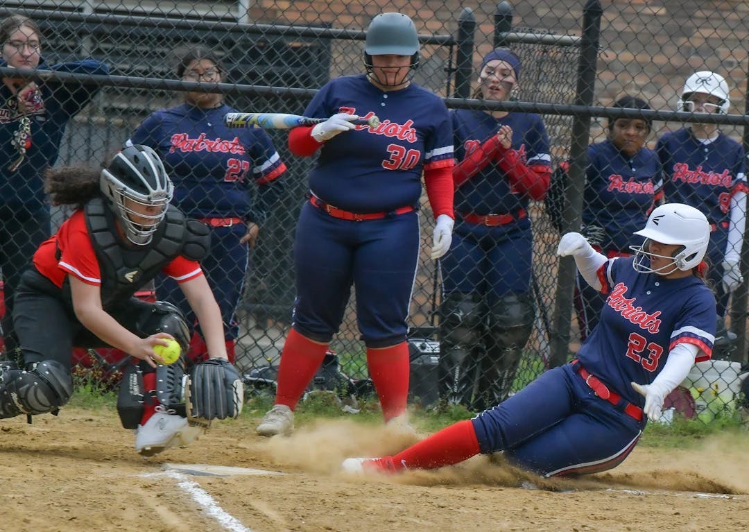 a softball player sliding into home plate during a game